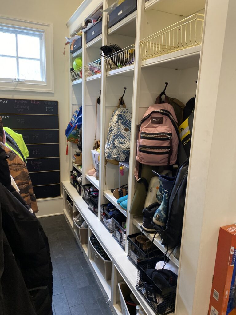 Mudroom cubbies with hanging backpacks, wire baskets, and a spot for each child's gear