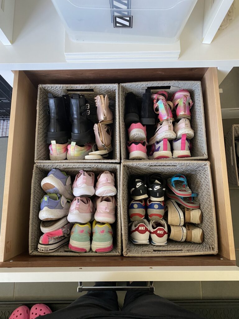 Mudroom shoe drawer after organization with woven baskets separating each family member's shoes