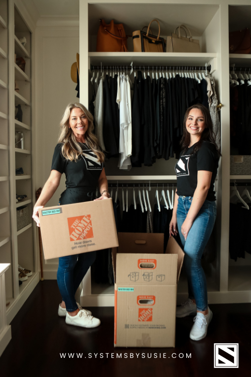 Two Professional Organizers Helping Unpack Boxes into a Primary Closet.