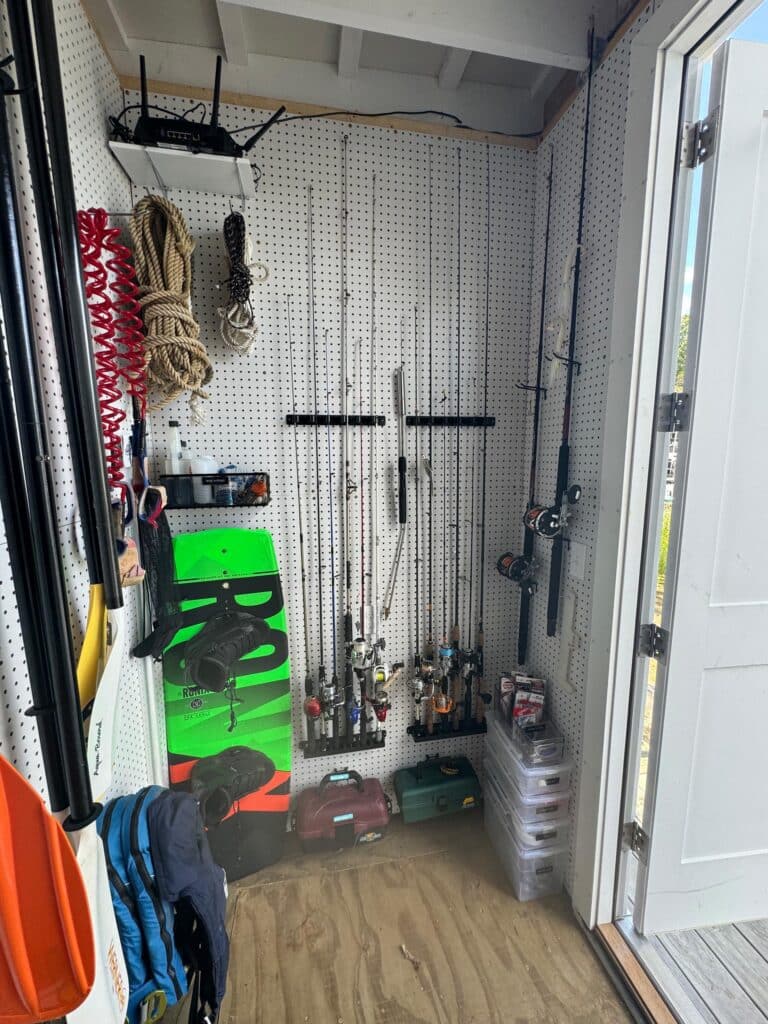 Fishing rods and other outdoor gear stored in a wall in a shed