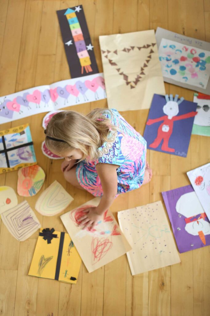 Girl going through her artwork as her family declutters before a move