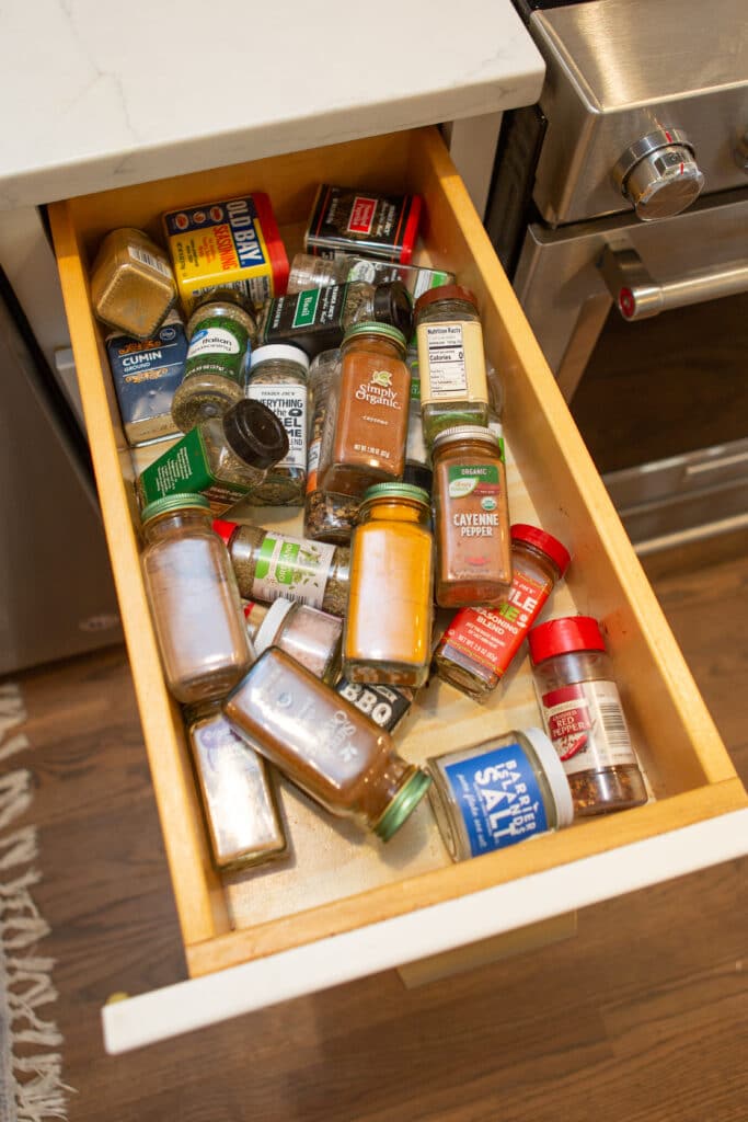 An unorganized spice drawer