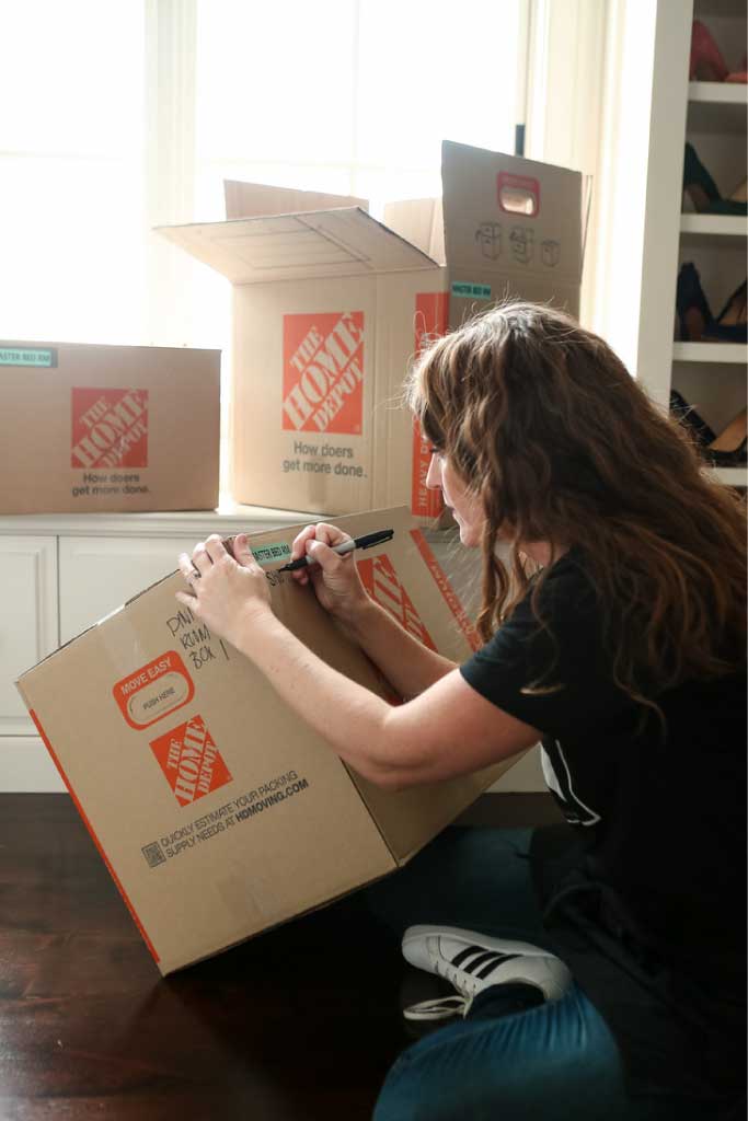 Professional organizer labeling a box for a sports relocation services