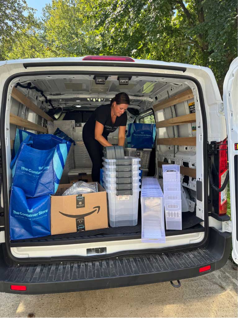 Susie stacking boxes in a van after a sports relocation move