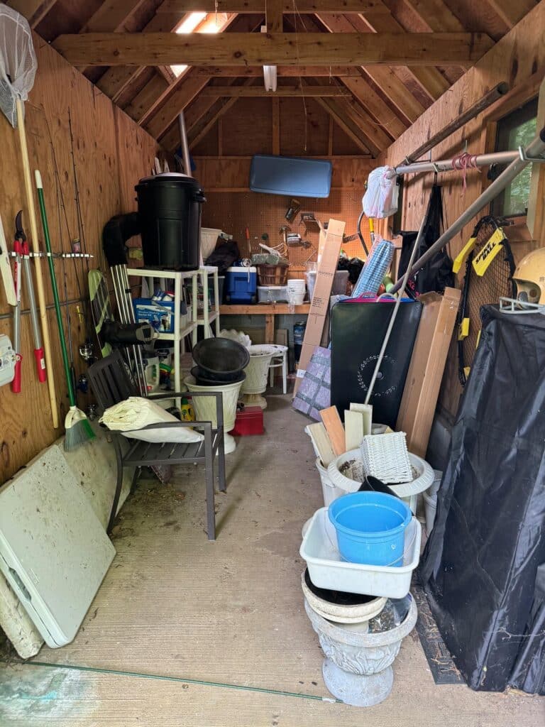 Cluttered backyard shed interior before professional organization in Annapolis, MD