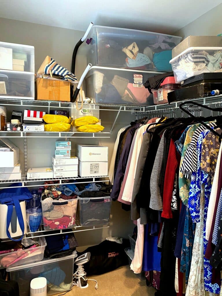 Corner of walk-in closet before organization showing overcrowded shelves with medical supplies and packed clothing rack