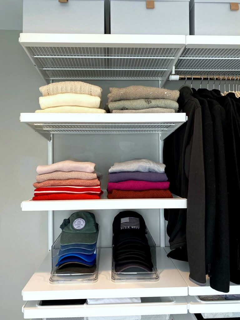 Organized closet shelves with neatly folded sweaters and clear acrylic hat and cap organizers after professional organization