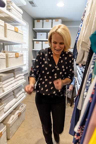 Homeowner laughing and dancing with joy in her beautifully organized walk-in closet at the project reveal