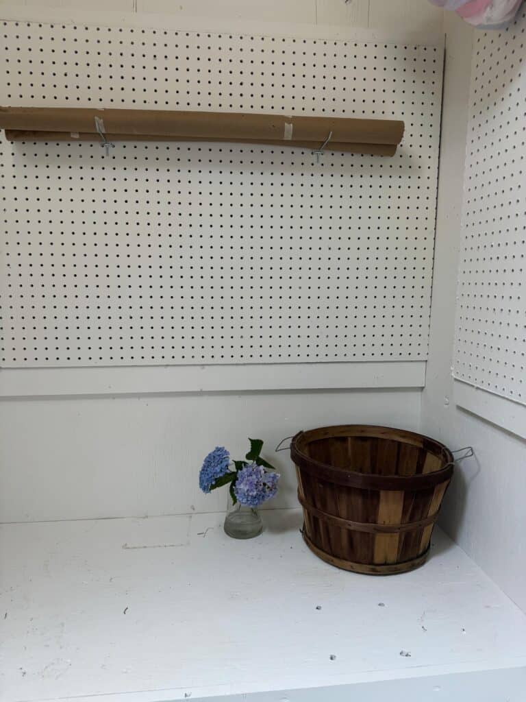 White pegboard and workbench corner in an organized Annapolis shed with fresh hydrangea flowers