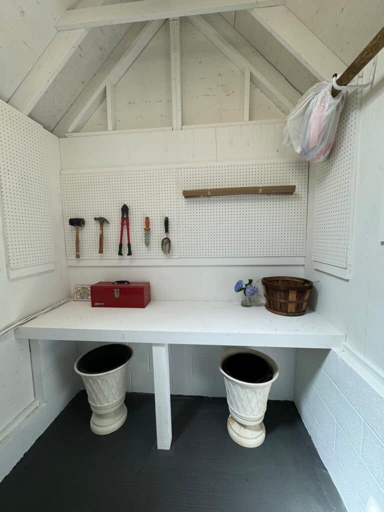 White workbench with pegboard and organized tools in a professionally organized Annapolis garden shed