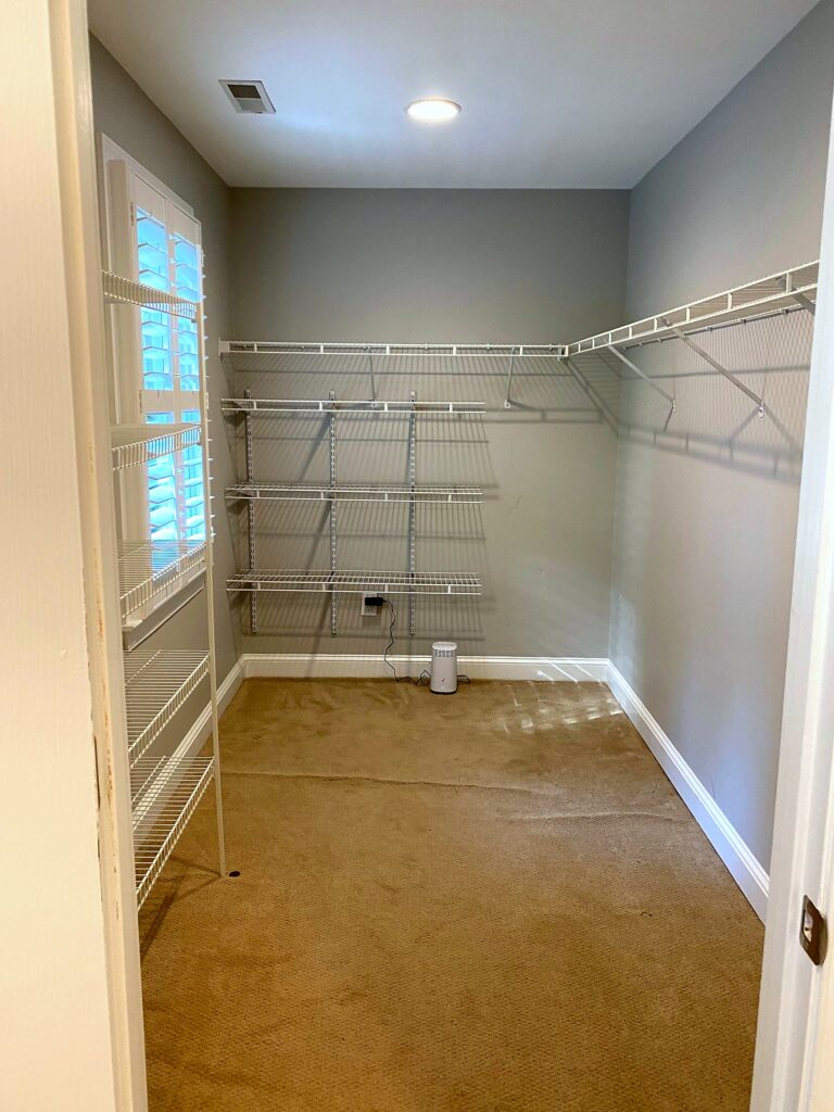 Empty walk-in closet with old wire shelving cleared out and ready for Elfa system installation