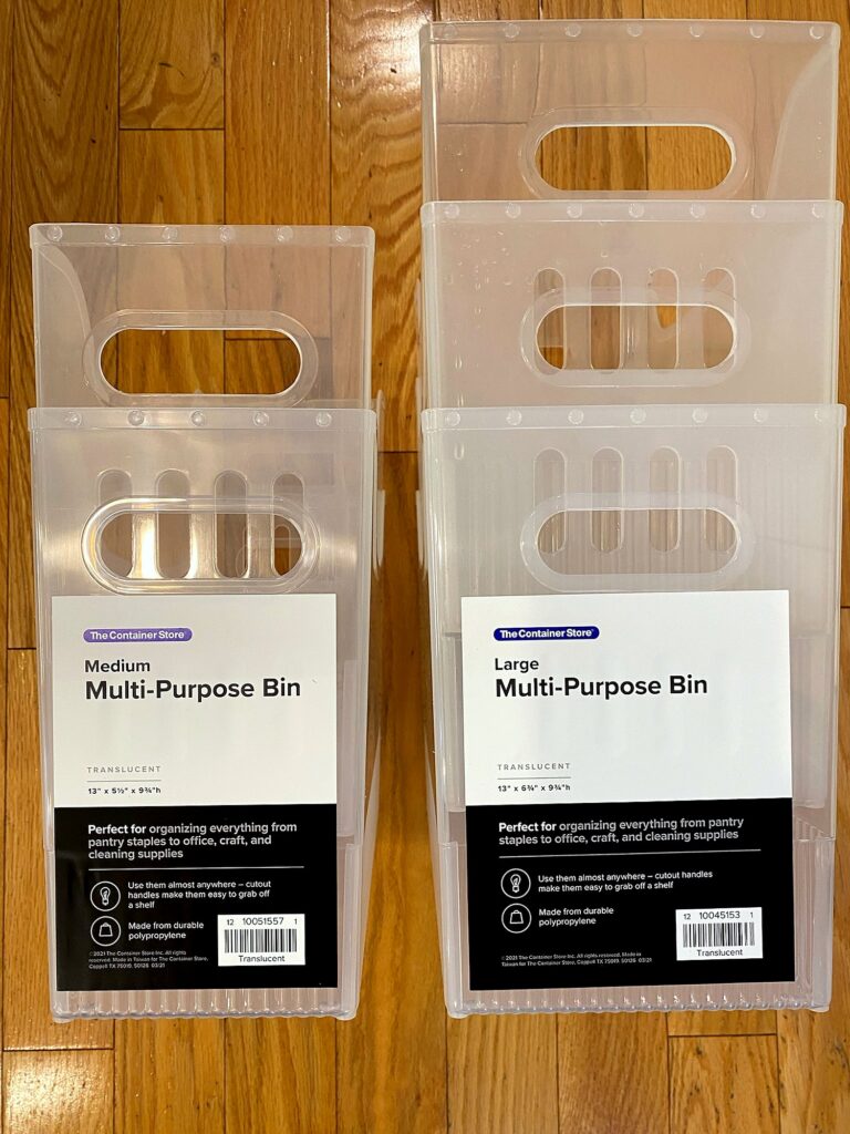 Medium and large Container Store translucent multipurpose bins in packaging used to organize a pull-out freezer