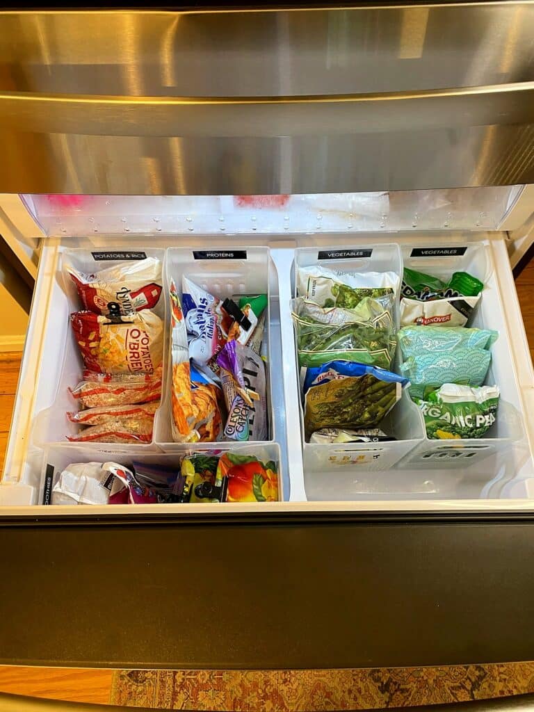 Organized lower pull-out freezer drawer with labeled bins for potatoes and rice, proteins, and vegetables