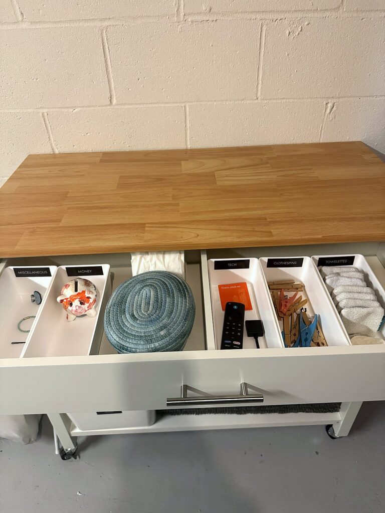 Folding cart drawer with divided organizers keeping small laundry extras sorted