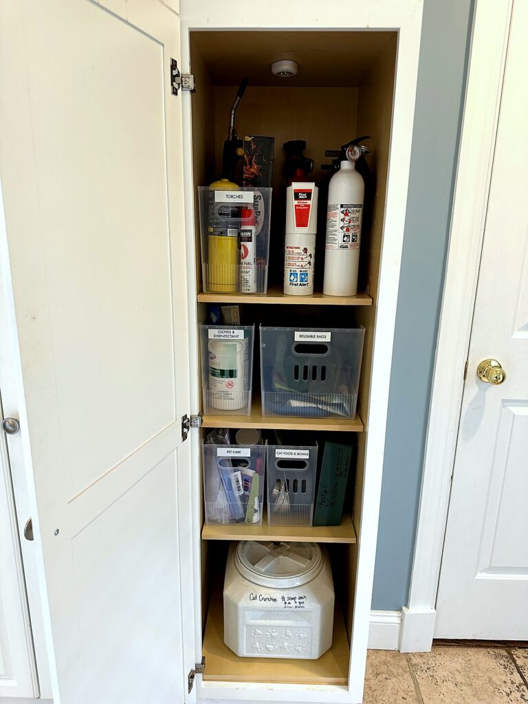 Utility closet shelves with labeled gray bins keeping laundry room extras grouped and easy to find